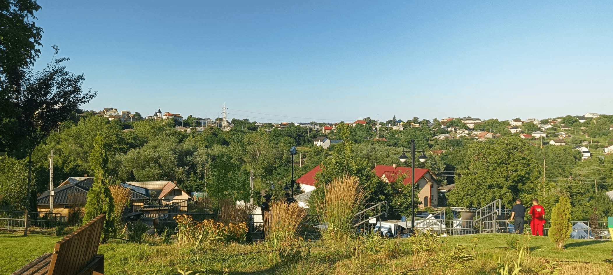 Peisaj rural cu dealuri și sat la răsărit